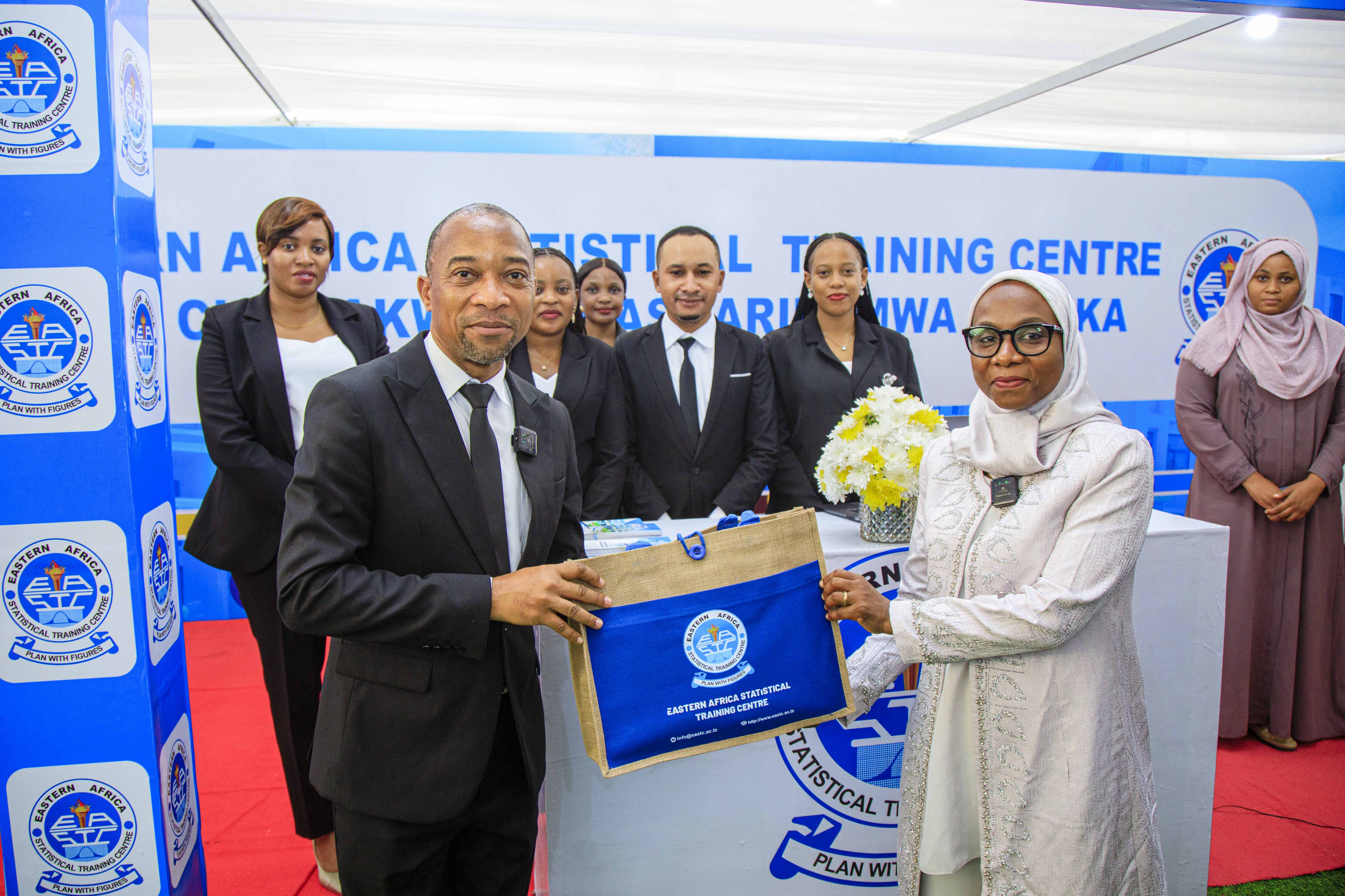 <p>EASTC Deputy Rector-Planning, Finance and Administration, Dr. France A. Shayo presenting a gift to Hon. Lela Muhamed Mussa, Minister of Education and Vocational Training-Zanzibar, when visited the booth of EASTC during the 6th Higher Education Exhibition in Zanzibar held at Mnazi Mmoja Grounds, on July 14-20, 2025.</p>
