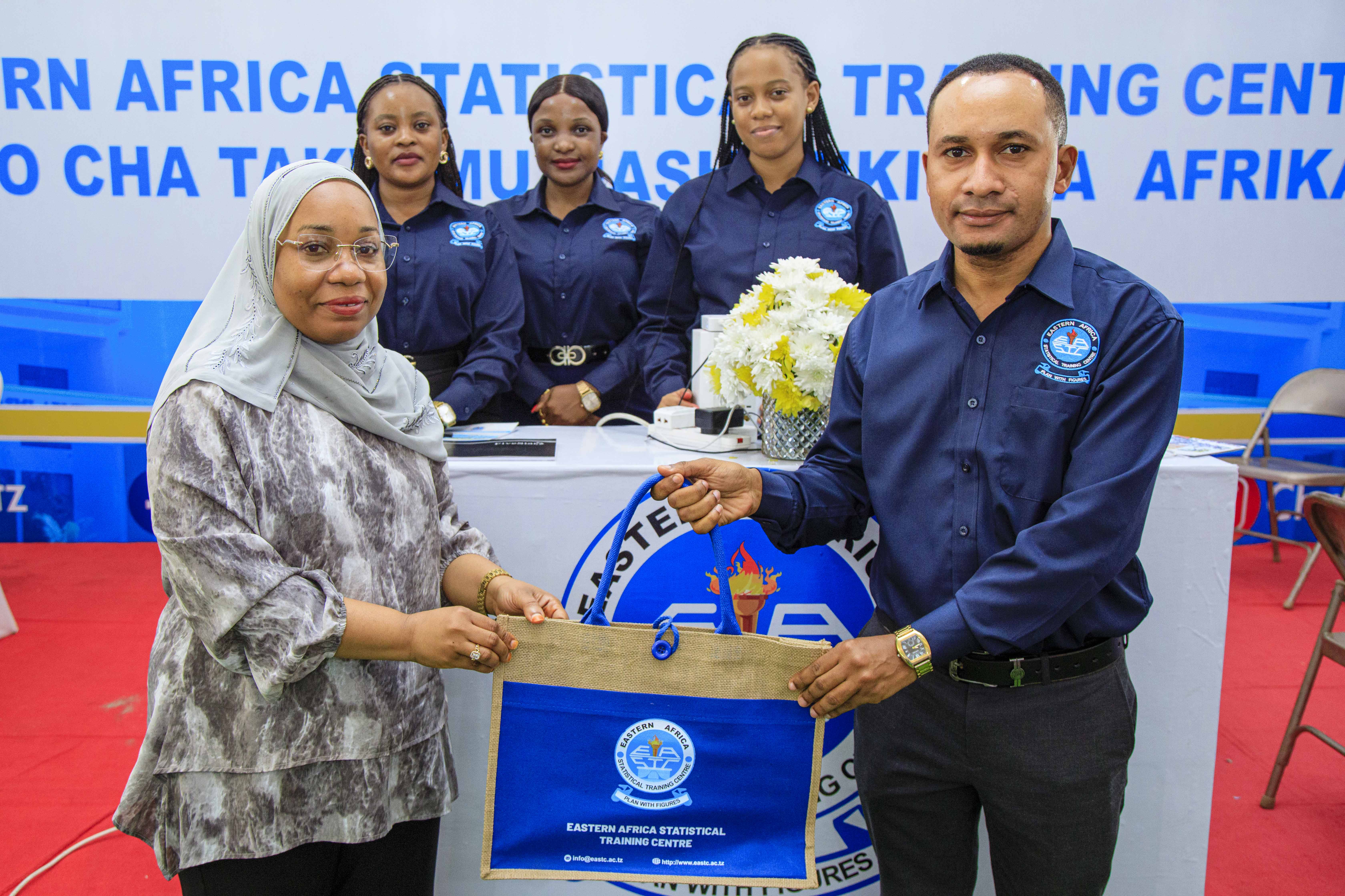 <p>EASTC Head of Communication and Marketing Unit Mr. Samuel Marandu presenting a gift to Ms. Umrat Suleiman Mohamed, Director of the Zanzibar Higher Education Students’ Loan Board, when she visited the booth of EASTC during the 6th Higher Education Exhibition in Zanzibar on July 19, 2025, held at Mnazi Mmoja Grounds.</p>